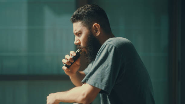 istock Man smoking in front of balcony to relieve stress from work. 1372098217