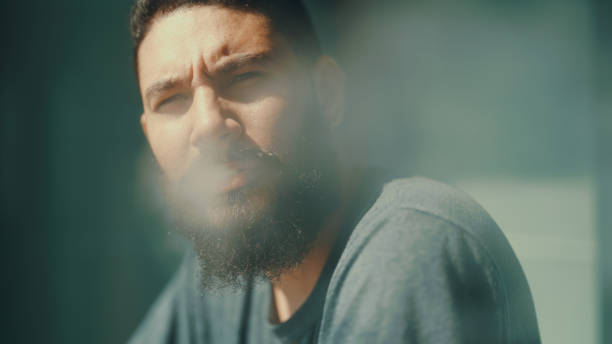 istock Man smoking in front of balcony to relieve stress from work. 1372098335
