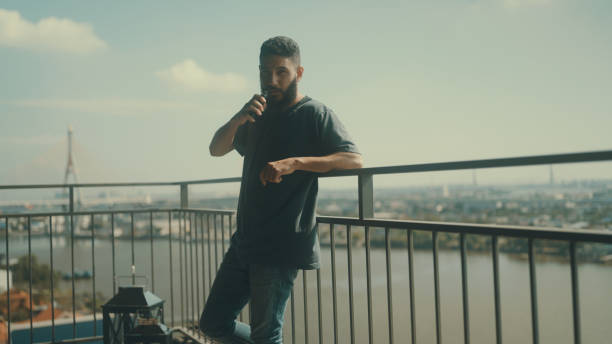 istock Man smoking in front of balcony to relieve stress from work. 1372098388