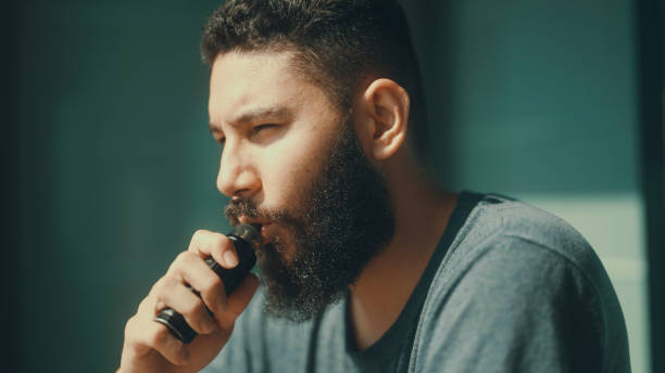 istock Man smoking in front of balcony to relieve stress from work. 1372098448