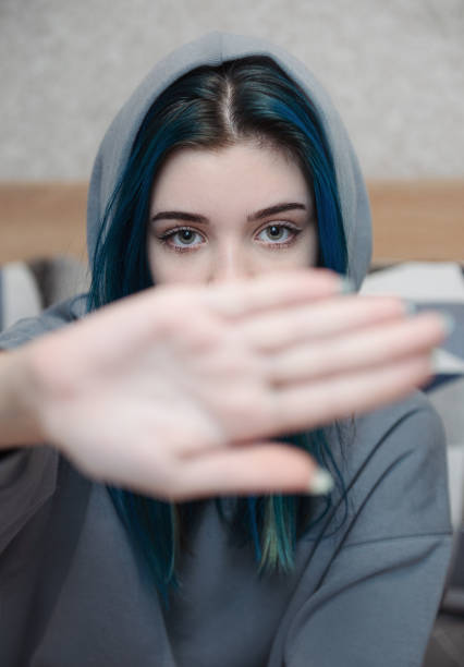 una adolescente de cabello azul se cubre la cara con la mano - cuenca fotografías e imágenes de stock
