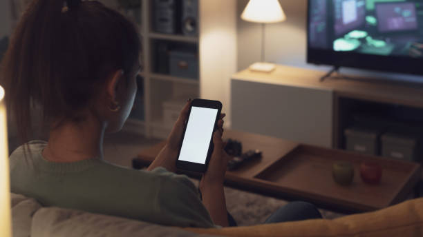 istock Teenager sitting on the couch and using her smartphone 1372099264