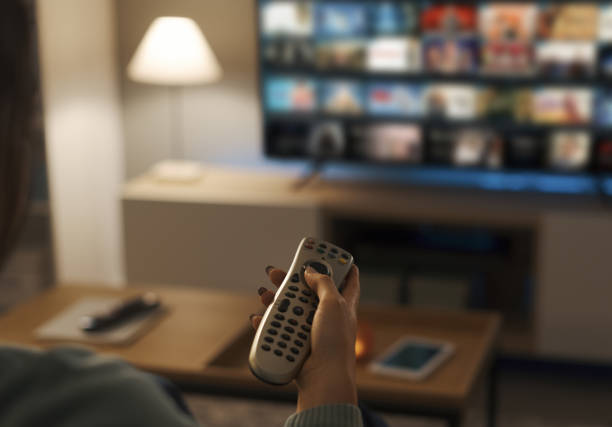 istock Young woman watching video on demand on her TV 1372099459