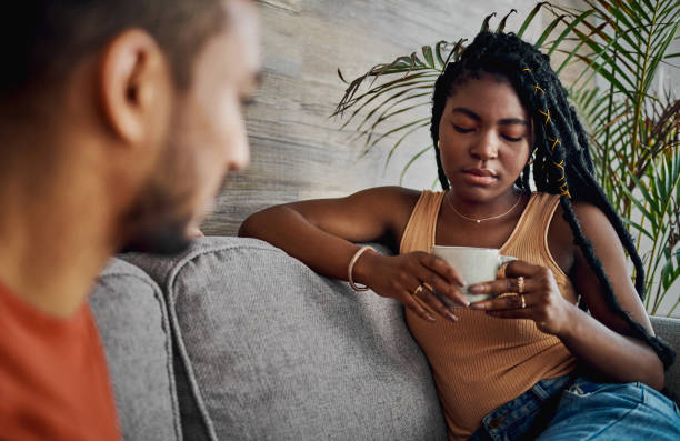 Shot of an attractive young woman sitting with her boyfriend in the living room at home and looking upset This isn't working out very well relationship breakup stock pictures, royalty-free photos & images