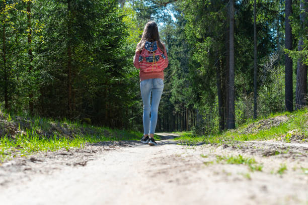 istock One young girl tourist with backpack walking on path through forest during summer day. Hipster lifestyle and solo trip. 1372100510