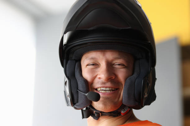 Woman adjusting the strap of her helmet, looking away.