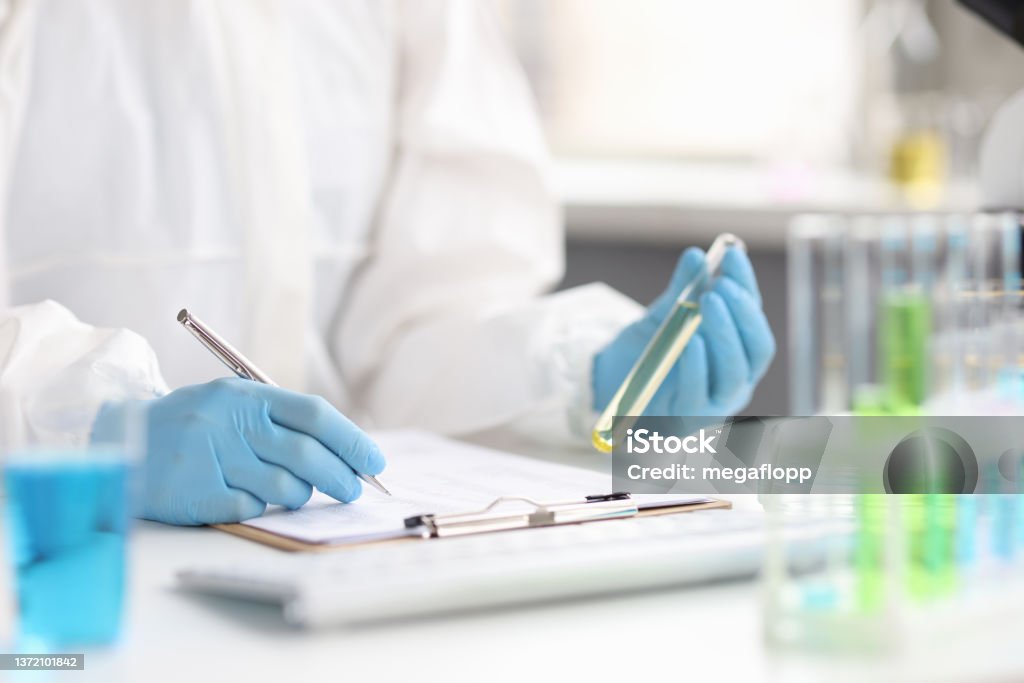 Study of fuel in vitro by scientist in laboratory Study of fuel in vitro by scientist in laboratory. Exploration of poisonous and toxic liquids concept Laboratory Stock Photo