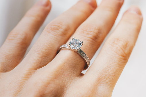 Primer plano de una mano de mujer con un anillo de diamantes photo
