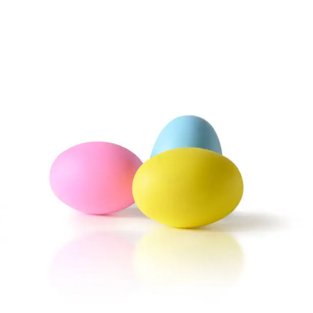 Easter three colorful yellow, pink and blue chicken eggs isolated on white background.