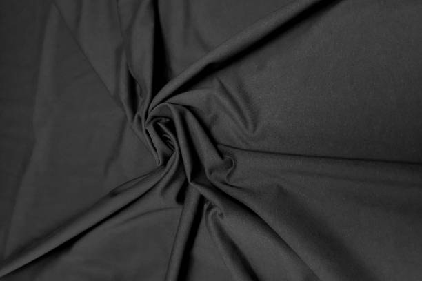 istock Black crumpled or wavy fabric texture background. Abstract linen cloth soft waves. Creases of satin, silk, and cotton. Smooth elegant silk or atlas luxury cloth texture. Bedding Sheets or blanket 1372103015