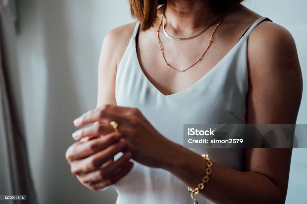 Portrait of An Asian woman with jewelry. Close-up portrait of Asian woman dressed in a posh jewelry of gold ring, necklace and bracelet. Necklace Stock Photo