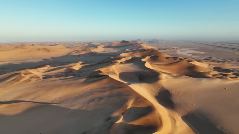 High angle view early morning desert dunes stretch to horizon with road