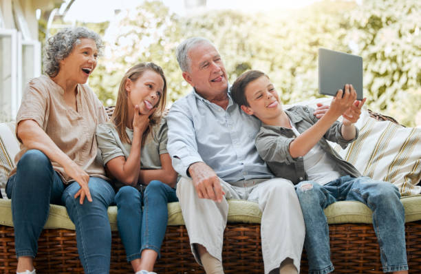 istock Shot of a young boy using a digital tablet while sitting at home with his sister and grandparents 1372107009
