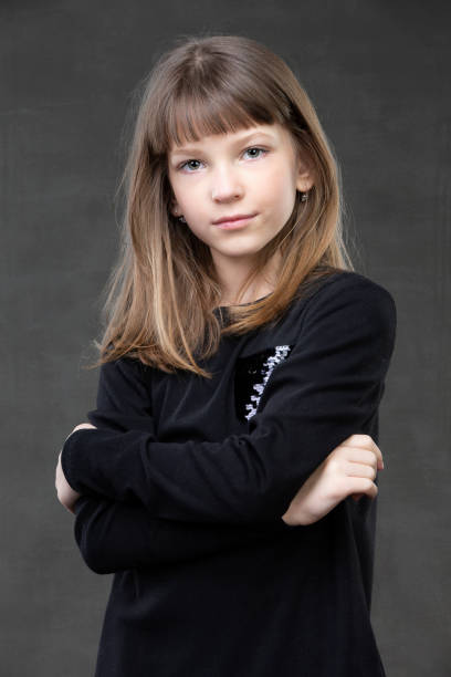 portrait of a beautiful pensive girl of ten years old on a gray background. - 10 11 years child human face female imagens e fotografias de stock