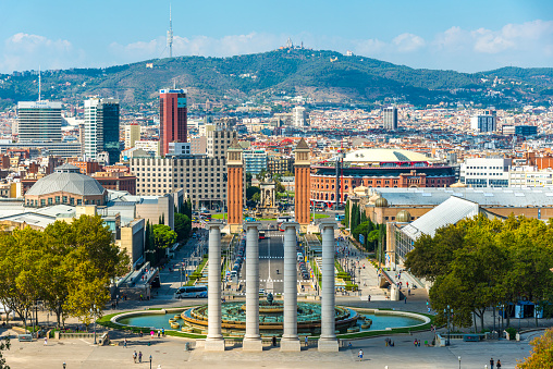 High angle view of Espana square under sunny day in Barcelona, Spain. There is Magic Fountain in frame. Horizontal composition. The Magic Fountain of Montjuic is a fountain located at the head of Avinguda Maria Cristina in the Montjuic neighbourhood of Barcelona, Catalonia, Spain. The fountain is situated below the Palau Nacional on the Montjuic mountain and near the Placa d'Espanya and Poble Espanyol de Barcelona.