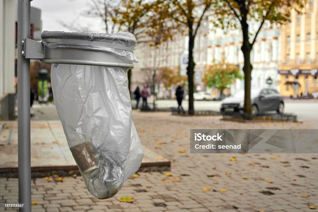 Garbage bin in the park Street waste basket with cellophane bag of in the city park Backgrounds Stock Photo