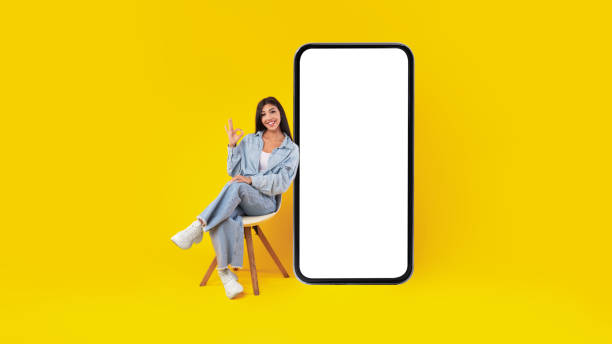istock Woman with big white empty smartphone screen showing ok gesture 1372113829