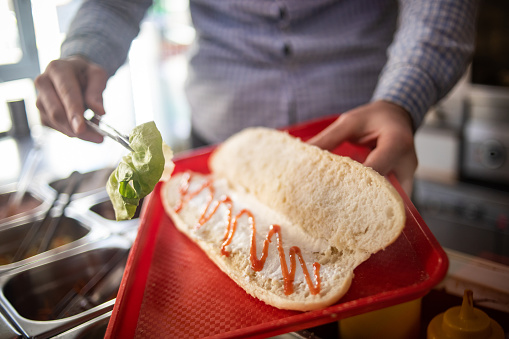The chef prepares a sandwich, street food is the sweetest