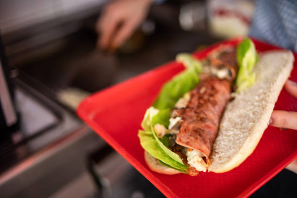 istock A fast food restaurant worker preparing a sandwich 1372113958