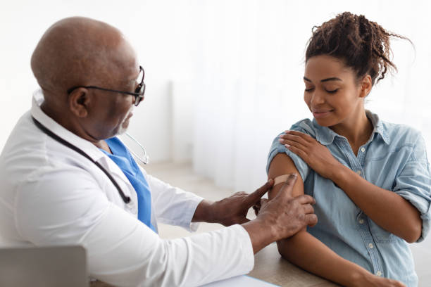 istock Pregnant Black Lady Getting Vaccinated, Doctor Applying Adhesive Bandage 1372114054