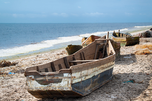 Fishing boats on the beach of the Atlantic Ocean in Muanda, DR Congo. The city of Muanda is located directly at the mouth of the Congo River into the Atlantic Ocean.