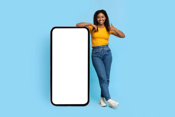 istock Positive african american lady posing with smartphone with blank screen 1372115218
