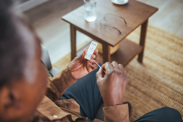 istock Senior man sitting, self test for COVID-19 at home with Antigen test kit. 1372115403