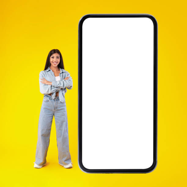 istock Woman standing near big white empty smartphone screen 1372116472