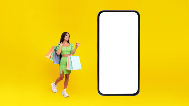 istock Woman pointing at white empty smartphone screen holding bags 1372116542