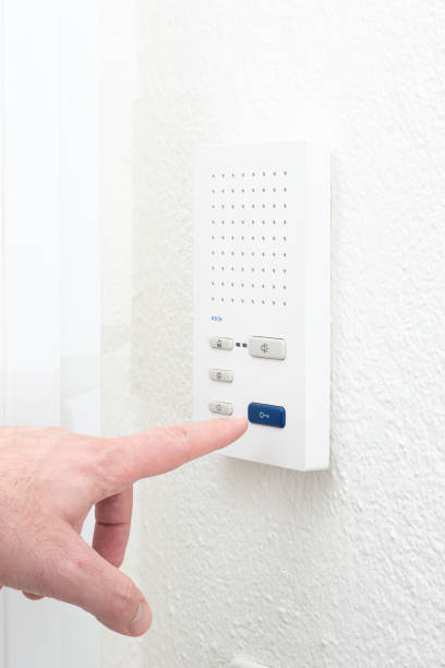 istock Caucasian male finger operating the intercom unit  from inside apartment. Close up interior shot, no face 1372116626