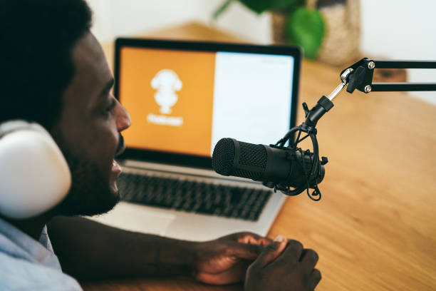 istock African man live streaming podcast session at home studio - Focus on microphone 1372117526