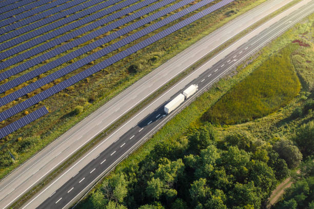 istock Truck on the road through a landscape with solar panels 1372120579