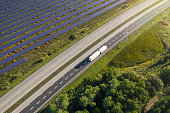 Truck on the road through a landscape with solar panels