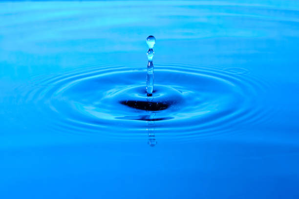 istock Splash water after drop falls.Blue abstract background with drop in water. 1372121039