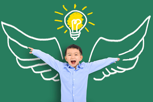 Smart kid with wing in class. Imagination, idea and success concept