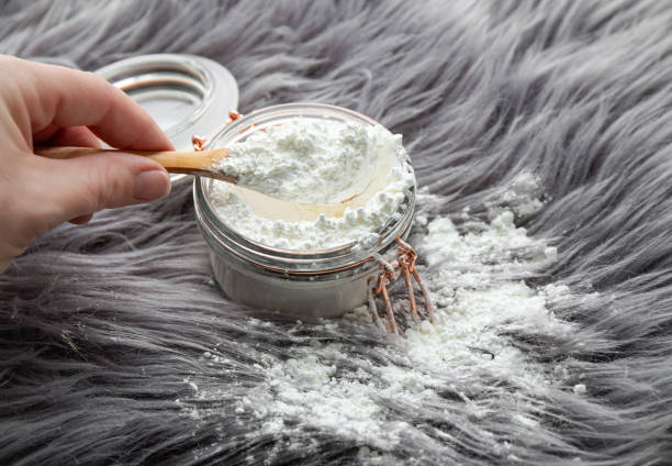 mão de mulher derramando amido de milho em pó em pó de pele de cabelo comprido para limpeza e remoção de manchas. conceito de limpeza doméstica natural. - starch - fotografias e filmes do acervo