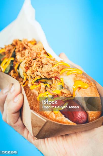 Freshly Prepared Hotdog With Lush Salsa In A Paper Box Food Delivery Or Junk Food Concept Blue Background Stock Photo - Download Image Now