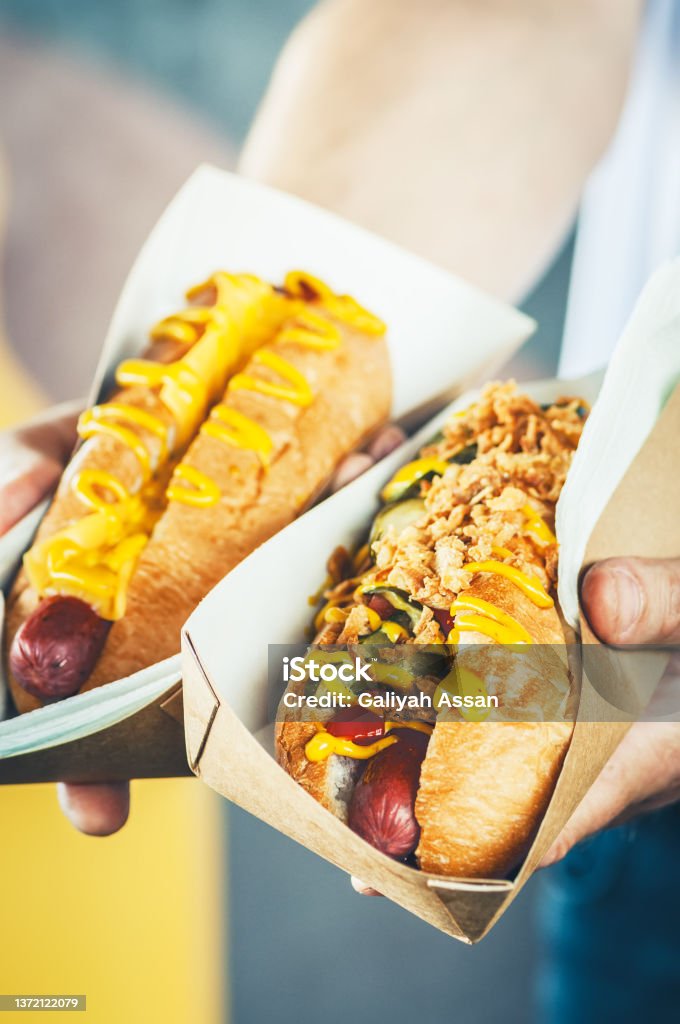 Two freshly prepared hotdogs in a paper box. Food delivery, take away, street food or junk food concept. Advice Stock Photo