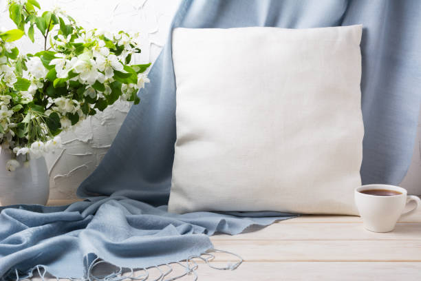 istock Pillow mockup with apple blossom branches and blue scarf 1372122272