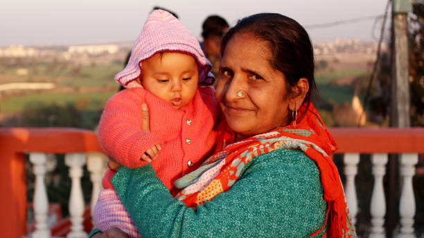 Grandmother And Granddaughter Happy Grandmother carrying her granddaughter in hand outdoors Indore, Madhya Pradesh, India. culture of india photos stock pictures, royalty-free photos & images