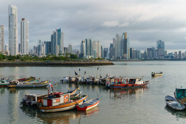 Fishing boats docked in front of modern skyscrapers in Casco Viejo Panama City Fishing boats docked in front of modern skyscrapers in Casco Viejo Panama City. Hazy day with calm waters. casco viejo photos stock pictures, royalty-free photos & images