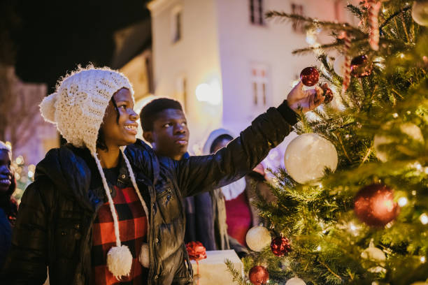 istock African American siblings looking at decorated Christmas tree 1372124697