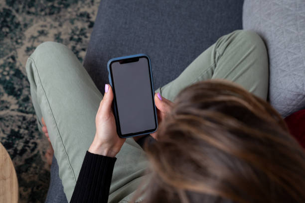 istock Woman using mobile sitting in the couch 1372125330