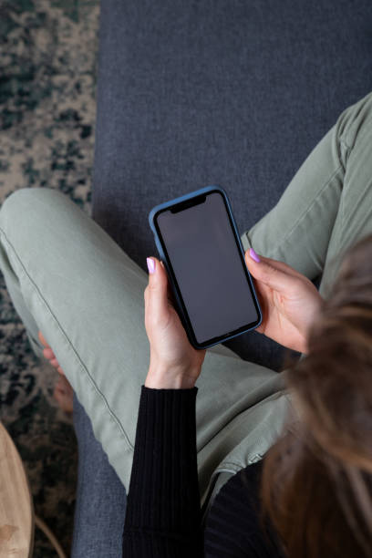 istock Woman using mobile sitting in the couch 1372125336