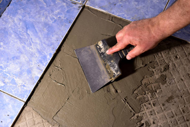istock The hands of a man with a spatula apply the solution to the floor. 1372125346