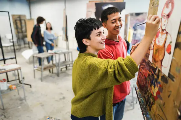 Photo of Multiracial students painting inside art room class at school - Focus on girl face