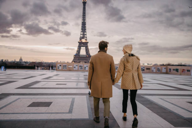 istock Smiling Couple holding hands while walking in the direction of Eiffel Tower 1372126900