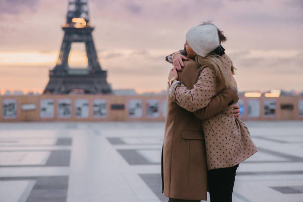 夕暮れ時の夕方、パリのエッフェル塔前で抱き合うカップル - boyfriend affectionate front view side view ストックフォトと画像
