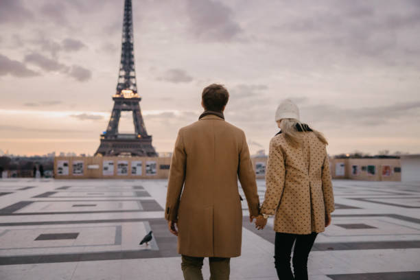 istock Couple holding hands while walking on Parvis des Droits de l'Homme with Eiffel Tower in background 1372127058