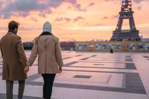 istock Young Couple holding hands while walking in the direction of Eiffel Tower, rear view 1372127157